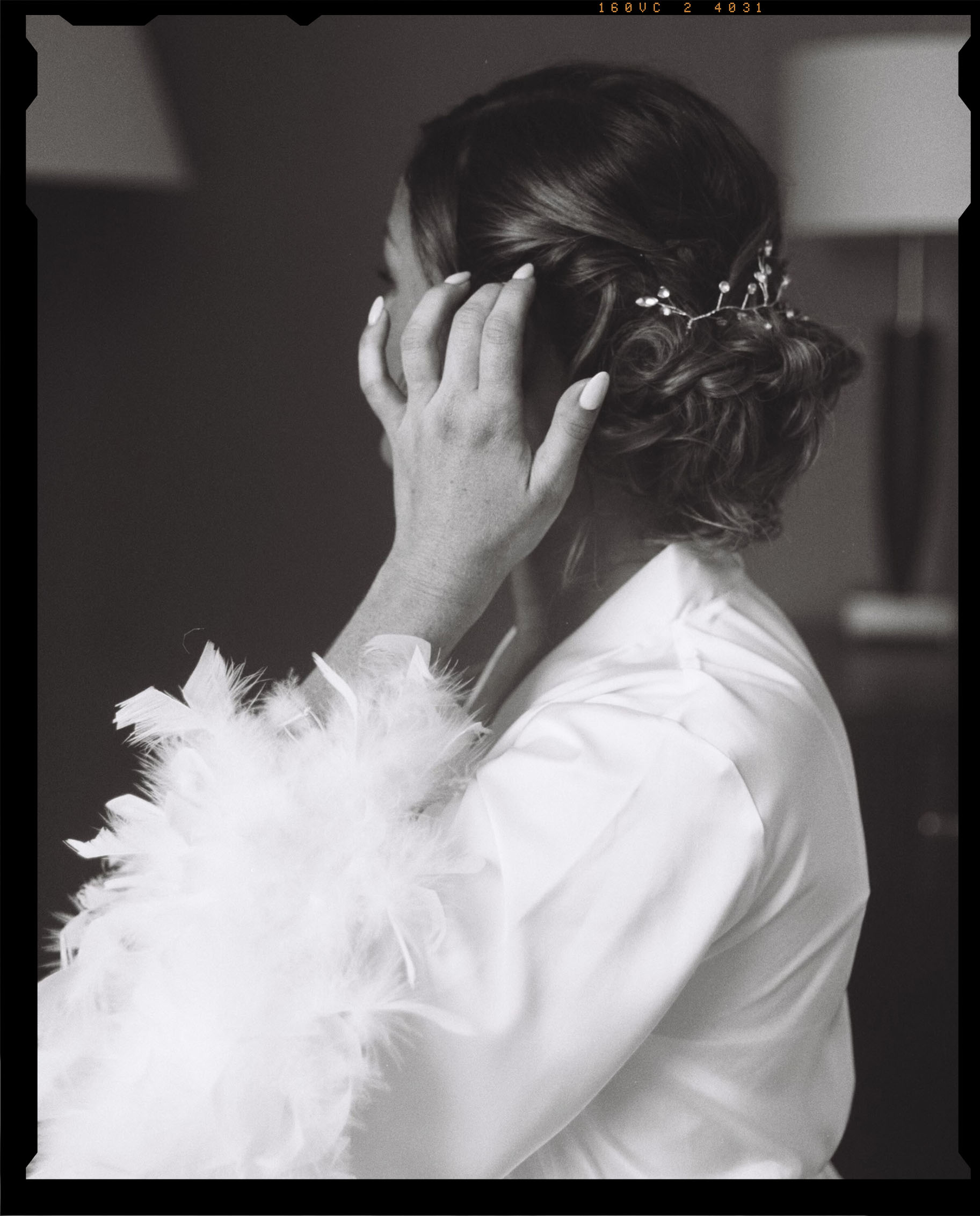 Black and white film photo of bride getting ready